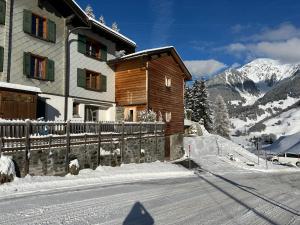 una casa al lado de una montaña cubierta de nieve en California House, en Klosters