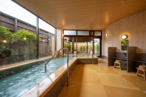 a swimming pool in a building with a large window at Hohoemino Kuyufu Tsuruya in Tendo