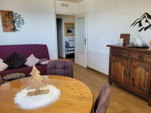 un soggiorno con un tavolo e un divano di Casa Del Cargol terrasse plein sud avec vue et garage a Font-Romeu-Odeillo-Via