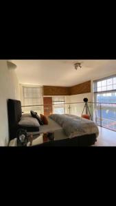 a bedroom with a bed and a large window at Lovely 1-Bedroom loft apartment in Cardiff