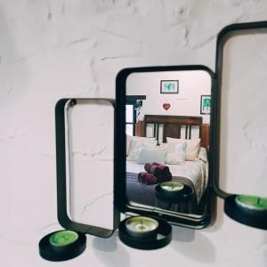 2 espejos en una mesa con 1 cama en una habitación en La Nozal - La Vallicuerra Casas Rurales en Mieres