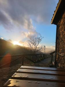 un sol se está poniendo sobre un puente de madera en La Faya - La Vallicuerra Casas Rurales en Mieres