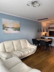 a living room with a white couch and a table at Ostsee Ferienwohnung in Sierksdorf - Hansa Park in Sierksdorf