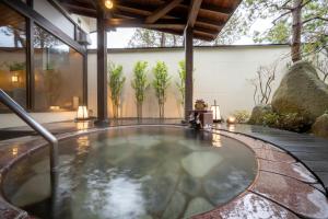 a hot tub in the middle of a house at Hohoemino Kuyufu Tsuruya in Tendo