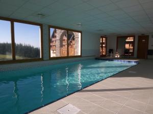 苏佩贝斯Lama-Gîte-des-Puys T3 Lamado vue époustouflante sud avec grande terrasse的大型客房带窗户,设有大型游泳池