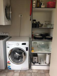 a kitchen with a washing machine in a kitchen at Acheron Cottages in Manapouri