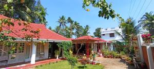a house with a red roof and a yard at Orchid Villa homestay in Vaikom +9 photos