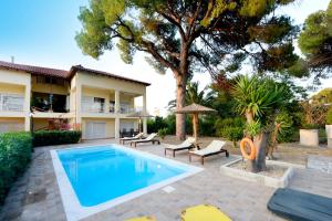 a swimming pool in front of a house at Island Rodos Pool Suites in Ialysos