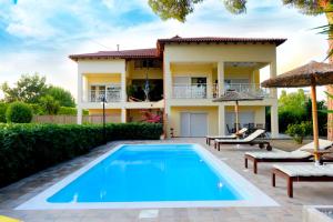 a villa with a swimming pool in front of a house at Island Rodos Pool Suites in Ialysos