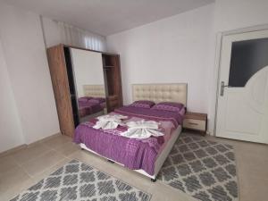 アンタルヤにあるЖемчужина Анталииのベッドルーム(紫色のベッド1台、鏡付)