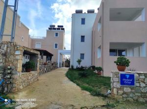un camino entre dos edificios con una señal azul en él en Diamond Deluxe Apartments Mastichari en Mastichari