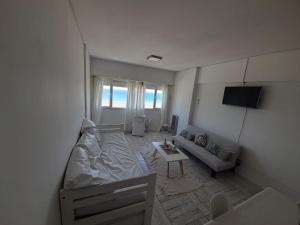 a living room with a couch and a tv at Enjoy Departamento Frente al Mar in Puerto Madryn