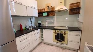 a kitchen with white cabinets and a stove top oven at Ferienwohnung Cottbuser City in Cottbus