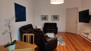 a living room with two leather chairs and a table at Ferienwohnung Cottbuser City in Cottbus