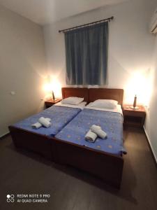 a bedroom with a bed with two towels on it at Diamond Deluxe Apartments Pool&Bar in Mastichari +24 photos