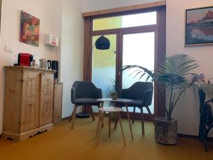 ein Zimmer mit 2 Stühlen, einem Tisch und einer Pflanze in der Unterkunft Haus Lasaun in Brixen