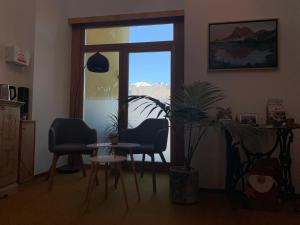 ein Wohnzimmer mit einem Tisch, 2 Stühlen und einem Fenster in der Unterkunft Haus Lasaun in Brixen