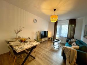 ein Wohnzimmer mit einem Tisch und einem blauen Sofa in der Unterkunft Downtown Apartment by NINJA SPACES - Kingsize-Bett, Küche, Netflix, Terrasse in Wuppertal