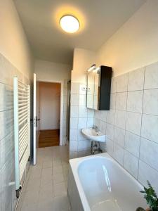 ein Badezimmer mit einer Badewanne und einem Waschbecken in der Unterkunft Downtown Apartment by NINJA SPACES - Kingsize-Bett, Küche, Netflix, Terrasse in Wuppertal