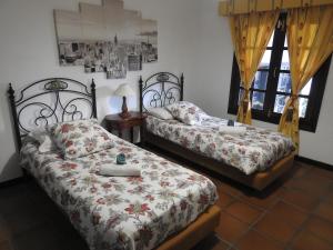 a bedroom with two beds and a lamp and windows at Habitaciones Doña Cris in Puerto del Carmen