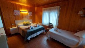 a hotel room with two beds and a window at Camping Solau in Espot