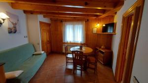 sala de estar con mesa y sofá en una habitación en Camping Solau, en Espot