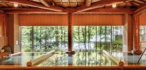 een grote kamer met een zwembad en een groot raam bij Sakunami Onsen Yuzukushi Salon Ichinobo in Sendai