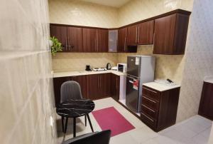 شقة هادئة في موقع مميز ودخول ذاتي في حي الصحافة في الرياض: مطبخ صغير مع دواليب خشبية وثلاجة