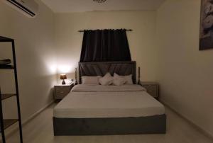 شقة هادئة في موقع مميز ودخول ذاتي في حي الصحافة في الرياض: غرفة نوم بسرير كبير وستارة سوداء