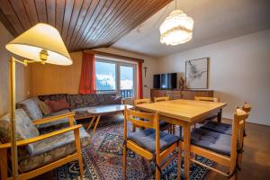 - un salon avec une table, des chaises et un canapé dans l'établissement Apartments Karl, à Ortisei