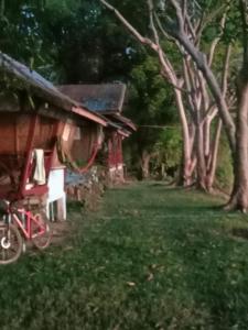 una casa con una bicicleta roja estacionada frente a ella en Mr.Bounhome Guesthouse and restaurant en Muang Không