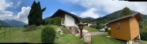 a small house in a field with mountains in the background at Ferienhaus Gerlitzen in Köttwein