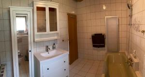 a bathroom with a sink and a shower with a tub at Ferienhaus Gerlitzen in Köttwein +5 photos