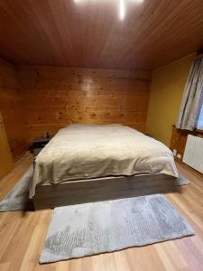 1 dormitorio con 1 cama en una habitación de madera en Haus zur Erholung, en Stalden