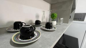 a kitchen counter with three cups and plates on it at Apartamento Locação Temporada em Foz do Iguaçu in Foz do Iguaçu