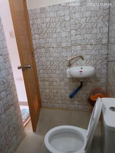 a bathroom with a white toilet and a sink at Ocean View Room Jay Henry's Transient House in Pagudpud