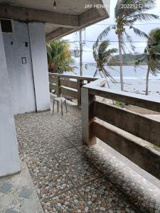 a building with a bench next to the beach at Ocean View Room Jay Henry's Transient House in Pagudpud