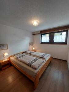 Cette chambre comprend un grand lit et une fenêtre. dans l'établissement Ferien in der Region Lenzerheide, à Lenz