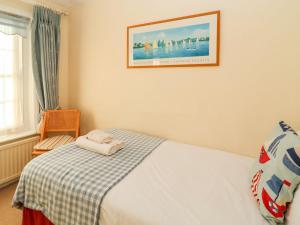 een slaapkamer met een bed en een foto aan de muur bij Winkle Cottage, Aldeburgh in Aldeburgh