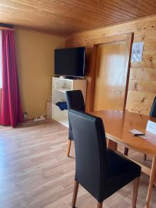 a dining room with a table and a television at Haus zur Erholung in Stalden