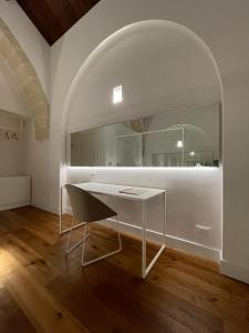escritorio blanco en una habitación con espejo grande en Hotel Saraceno Al Faro, en Taranto