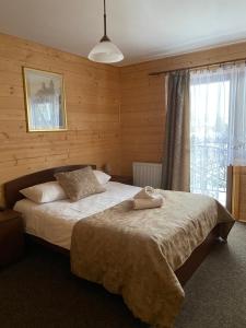 a bedroom with a bed with a towel on it at Pokoje Gościnne Przy Drodze in Białka Tatrzańska