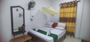 a small room with a mirror and a bed at Homely Guest in Habarana
