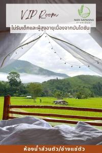 a bed with a view of a green field at สะปัน กลางนา คาเฟ่ Sapan Klang Na Cafe in Ban Huai Ti