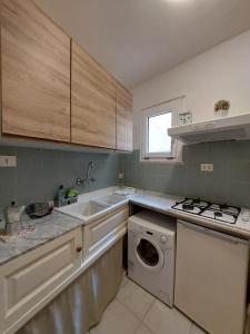 a kitchen with a sink and a washing machine at Casa Minniti in Syracuse