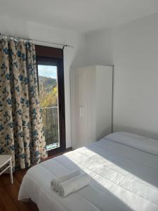 ein Schlafzimmer mit einem Bett und einem großen Fenster in der Unterkunft Casa Rural Bajadilla 5 in Atajate
