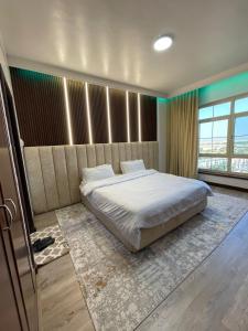 a bedroom with a large bed and a large window at relax room in King Abdullah Economic City