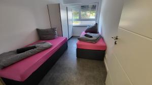 duas camas num pequeno quarto com uma porta em Luxus Ferienwohnung Irxleben em Irxleben