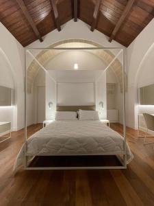 1 cama con dosel de cristal en una habitación en Hotel Saraceno Al Faro, en Taranto