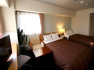 Voodi või voodid majutusasutuse HOTEL LiVEMAX BUDGET Chitose toas